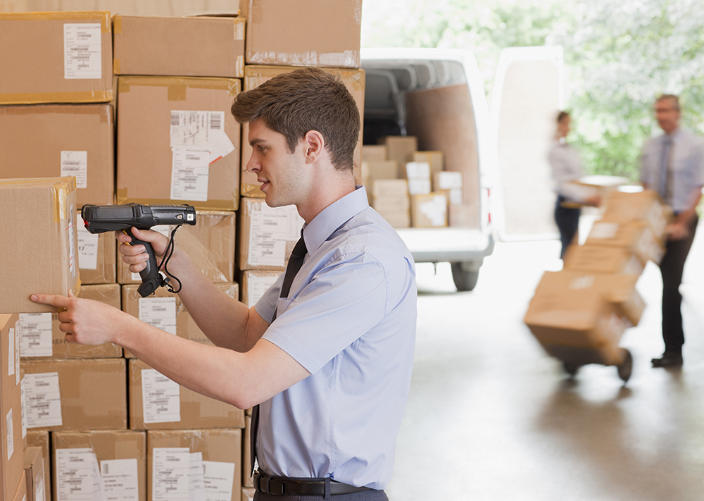 A warehouse worker using a scanner that is managed and secured by the SOTI ONE Platform