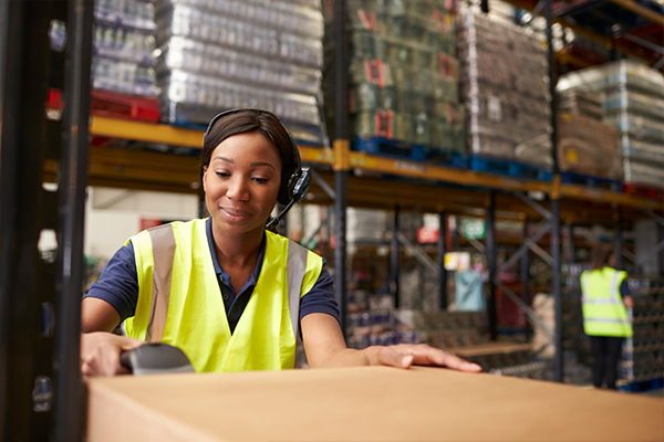 A female warehouse worker using a scanner that is managed and secured by SOTI's MDM solution